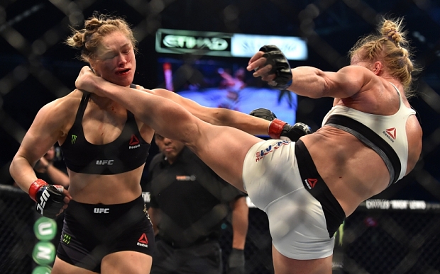 Holly Holm of the US (R) lands a kick to